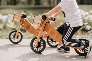 Kinderfeets Tiny Tot Plus tricycle balance bike wooden training bike running bike no pedals toddler children kids birch wood pink rose and wooden crate basket